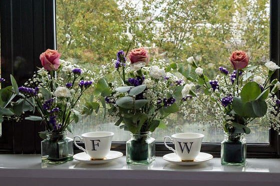 Pair of Cup and Saucers on Window Ledge with Flowers and F&W Initials for Wedding